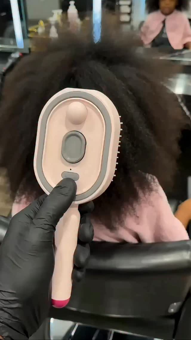 Person using a hairbrush on a client's hair in a salon setting
